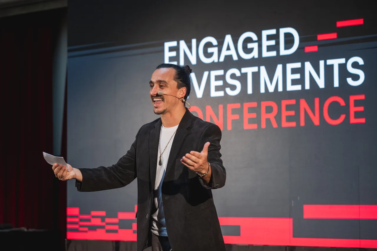 James Langer smiling and gesturing while hosting the Engaged Investments Conference